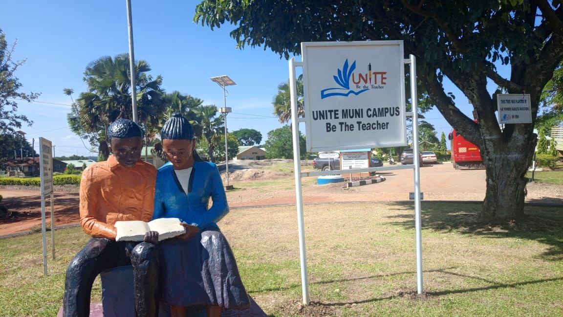 Statue of two students reading beside new UNITE signage at the Muni Campus in Arua City, Uganda