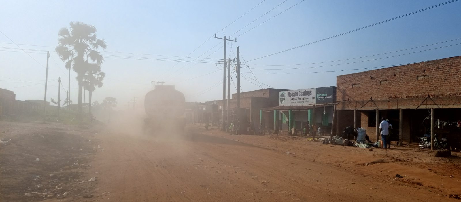 Heavy trucks carrying goods to DR Congo pass through the dusty Onduparaka commercial area in Arua City, Uganda.