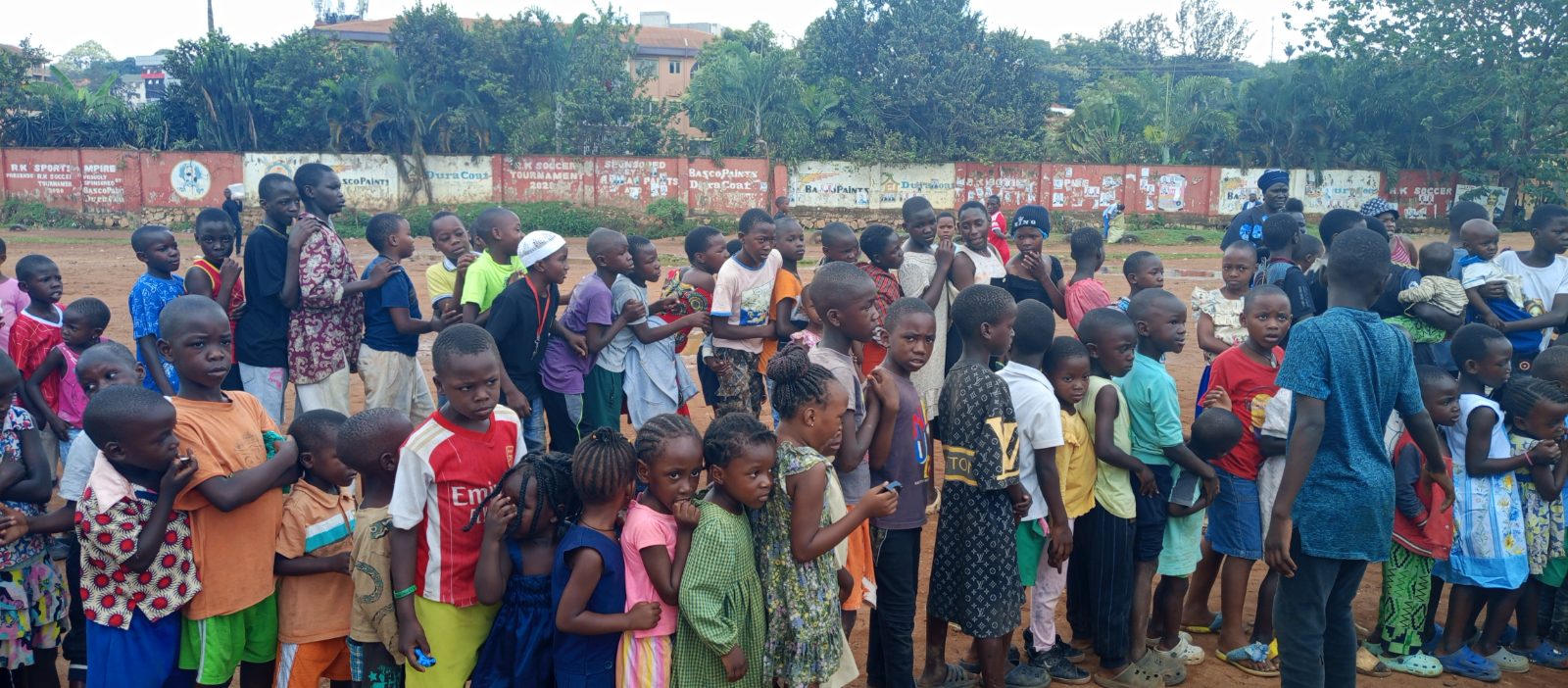 Katanga residents and children receive free meals during Dr. Michelle Corral’s community outreach in Kampala.