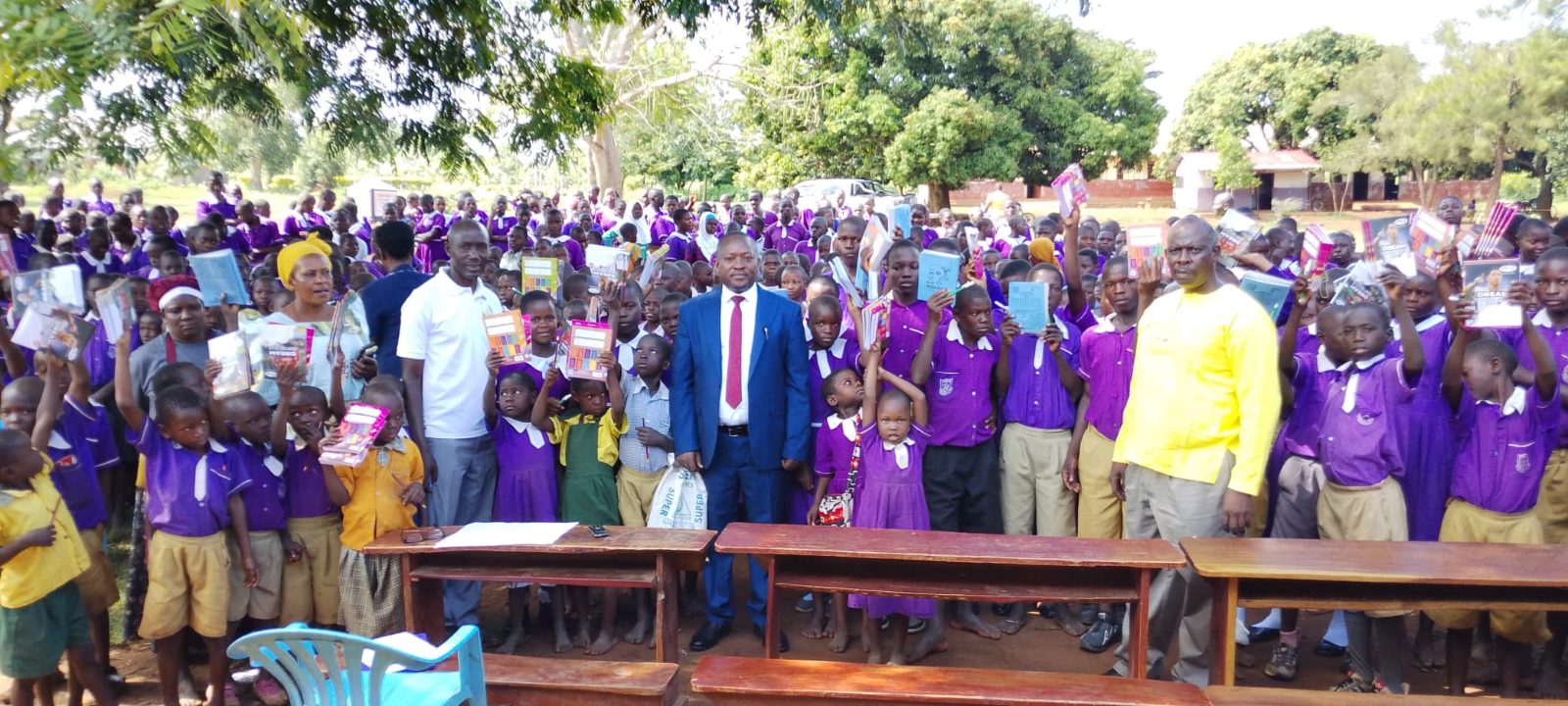 Iganga RDC Sewandiji Eric standing with local leaders, teachers and community members during a group photo after distributing scholastic materials to needy pupils in Iganga District.