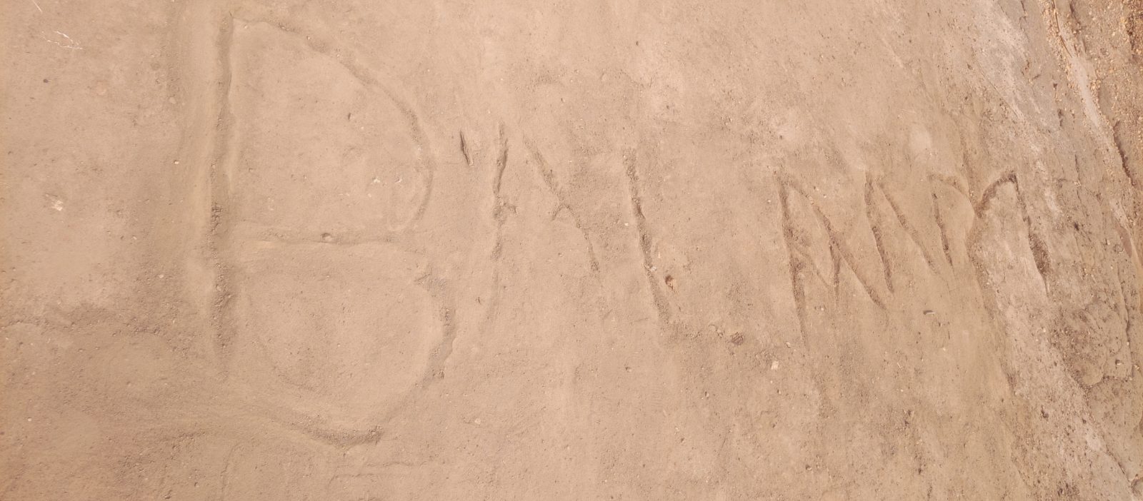The name “Balaam” clearly written on the sand by children.